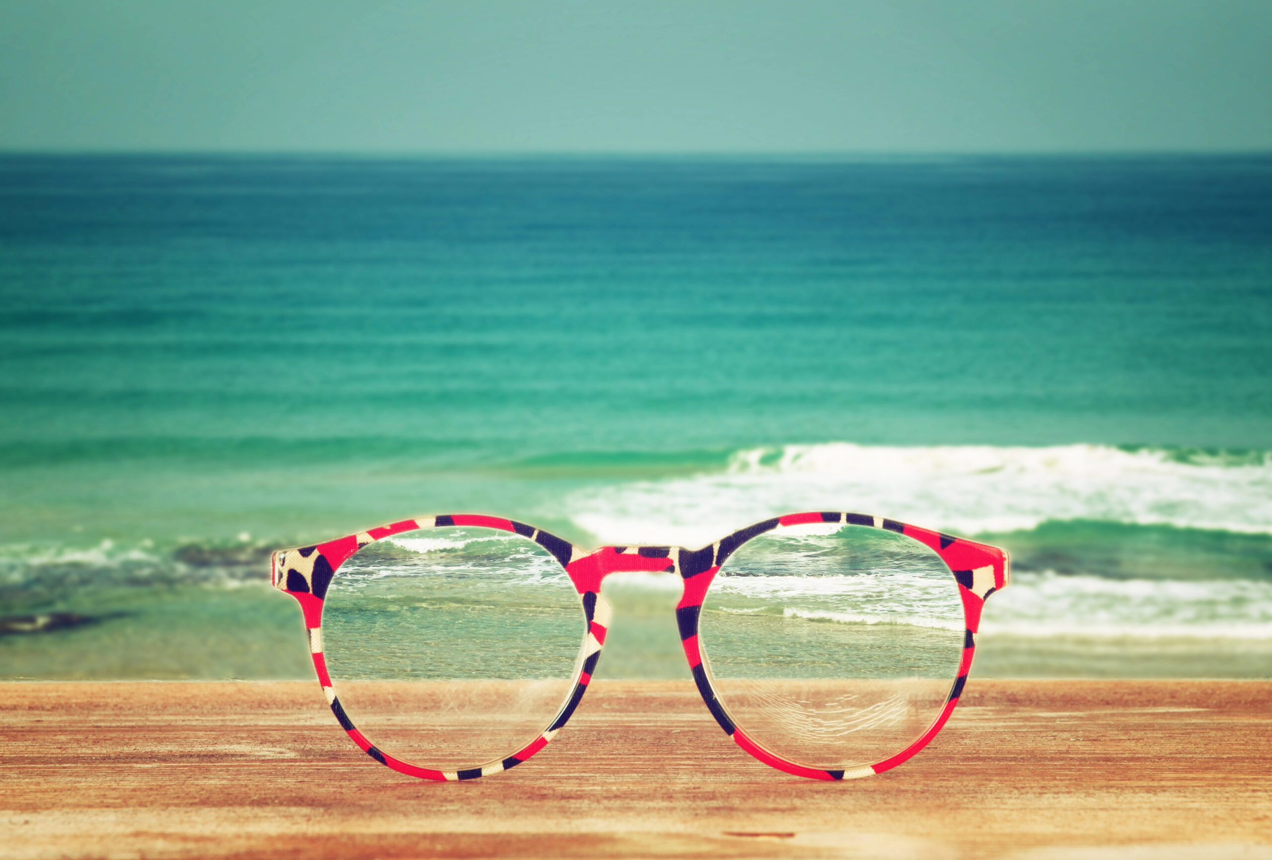 Glasses with a beach in the background.