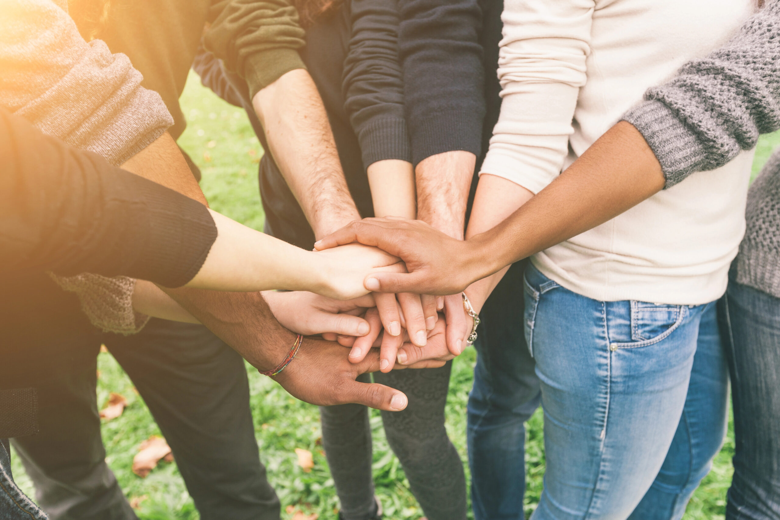 Several people with their hands in the center of the group.